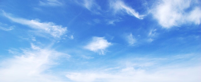 Blue sky background with tiny clouds..